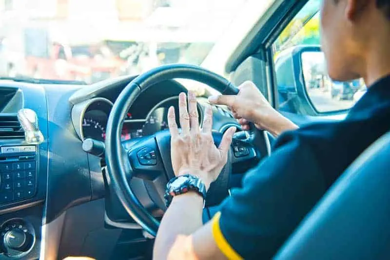 a man presses a siren in a car