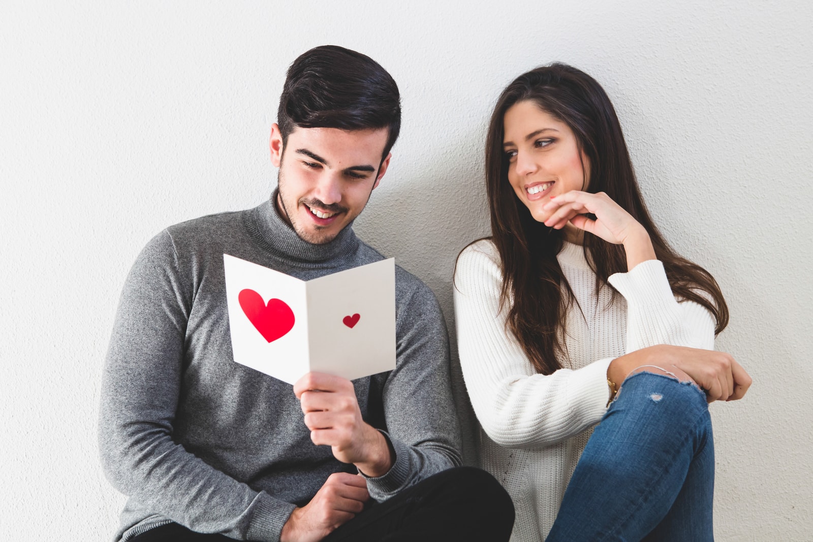 un hombre sonriente lee una tarjeta de cumpleaños de su novia