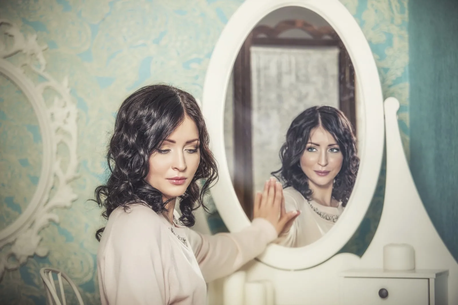 a woman standing next to a mirror