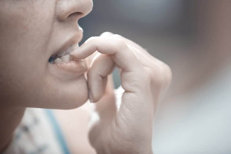 close up photo of woman puts finger in mouth