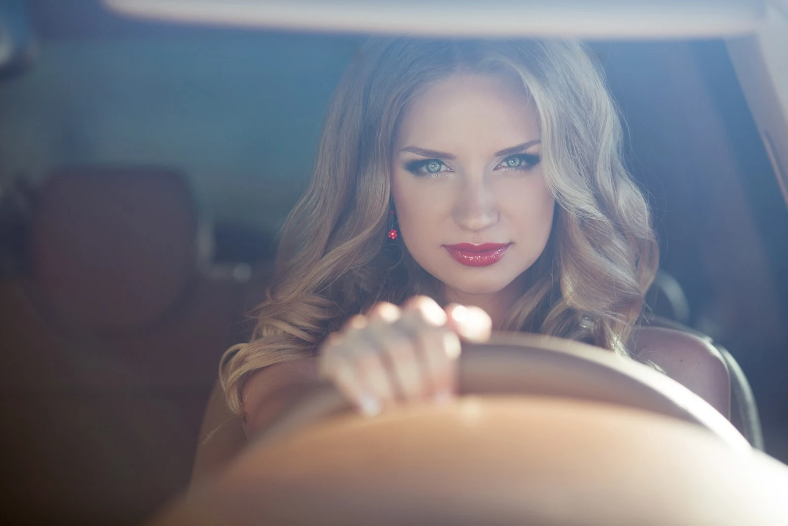 confident blond woman driving car