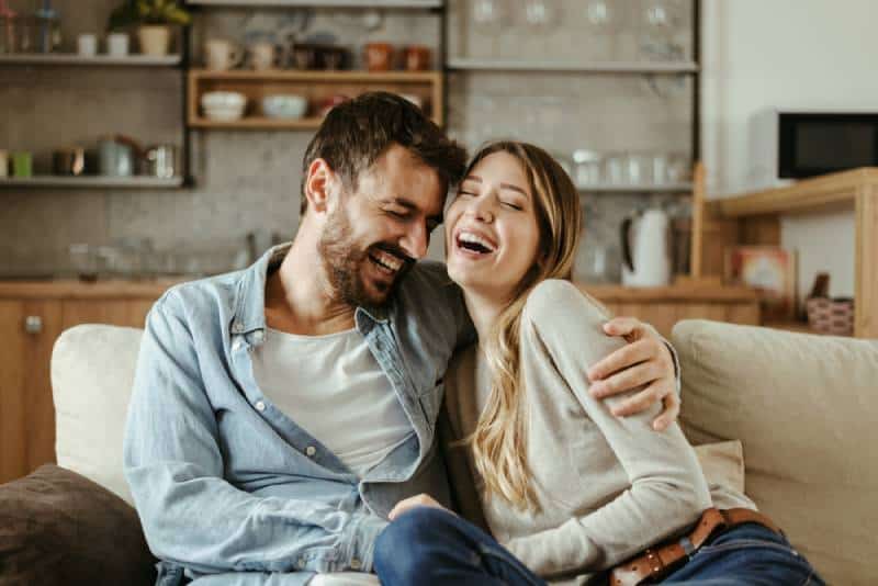 casal a abraçar-se e a sorrir na sala de estar