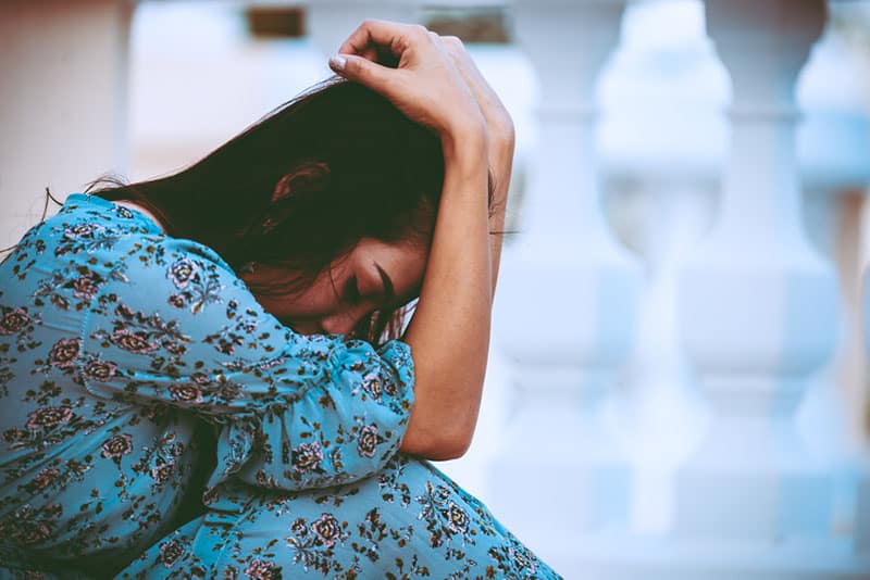 depressed woman sitting on the floor