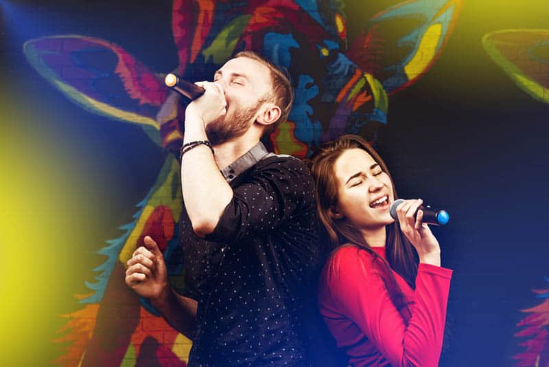 man and woman singing on microphone