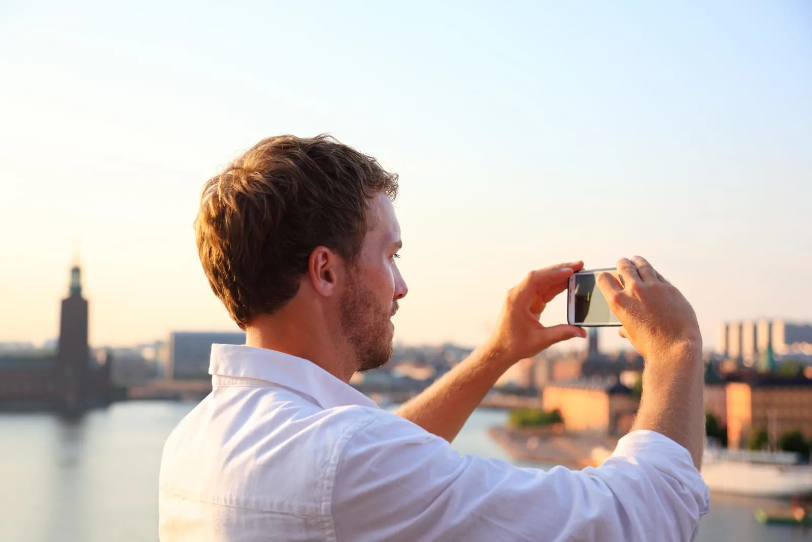 man taking photograph of sunset