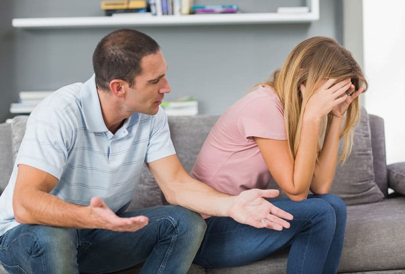 hombre hablando con mujer triste en el sofá