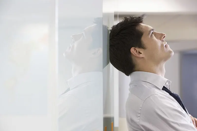 mindful man standing by the wall
