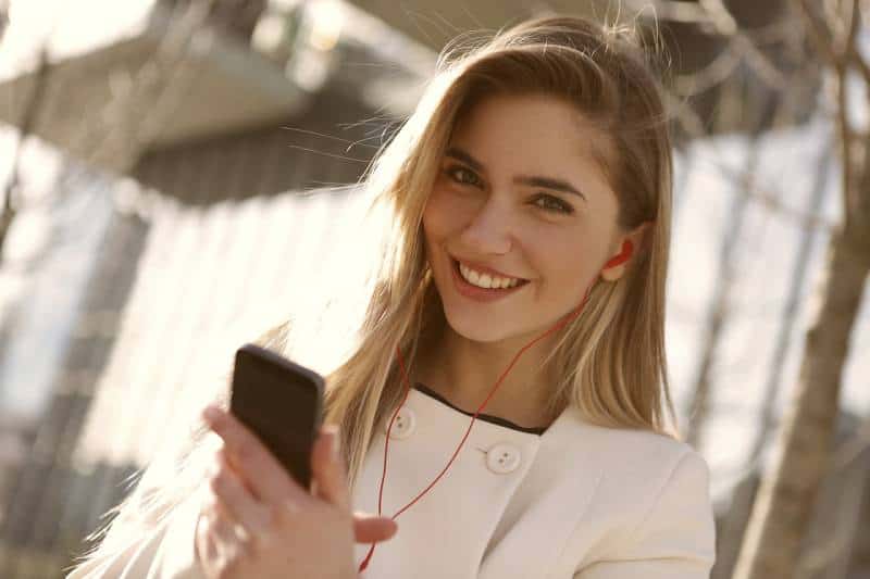 retrato de chica sonriente tecleando su teléfono