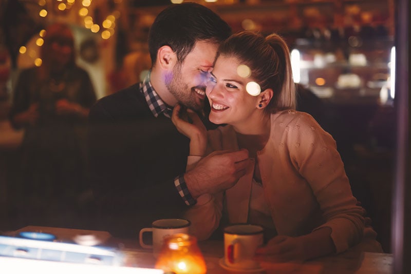 romantic couple cuddling at cafe