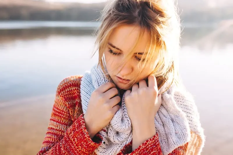 sad woman standing at lake