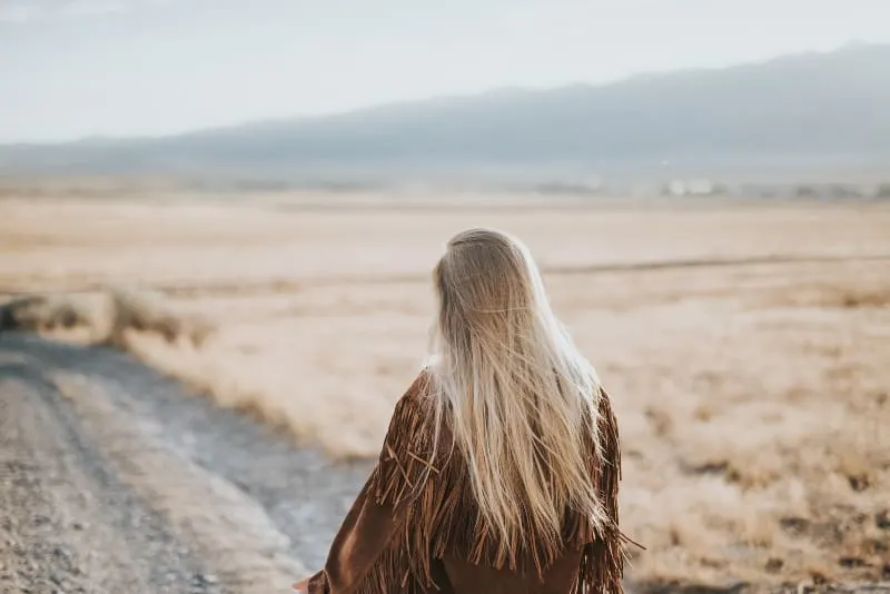 girl with long blonde hair walking in nature