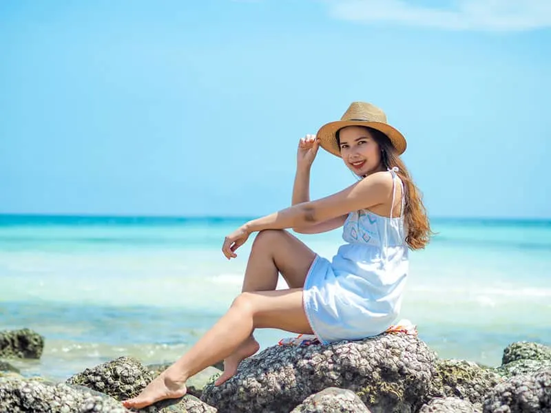 Happy young asian woman enjoy summer vacation on the beach.