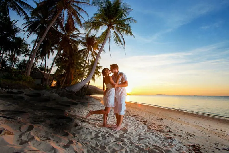 couple hugging at sunset on a tropical beach
