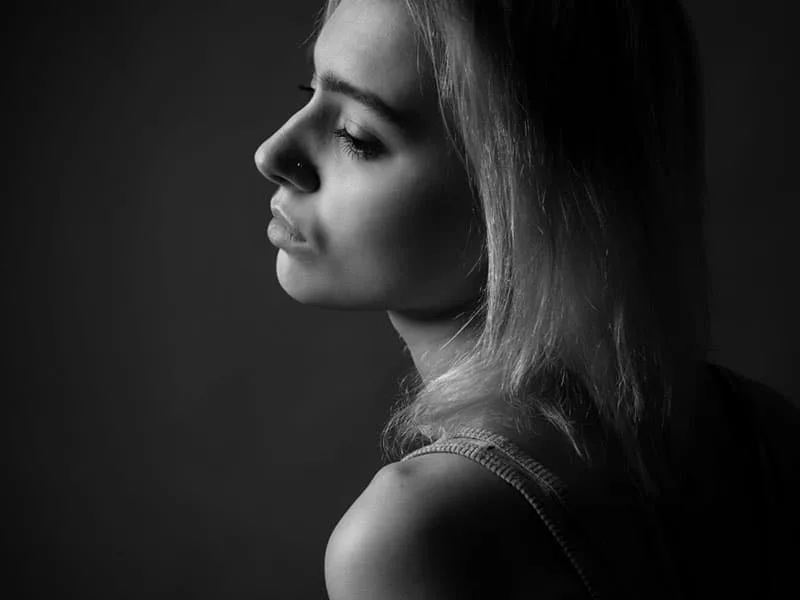 Portrait of girl in studio. Black and white. Profile.