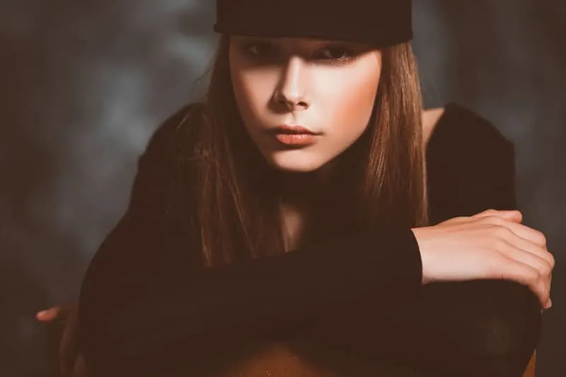 A close up portrait of a beautiful young girl in a cap posing in the studio. Beauty, cosmetics.