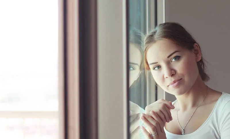 beautiful woman stands in front of the window