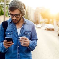 homem com um café a caminhar pela rua