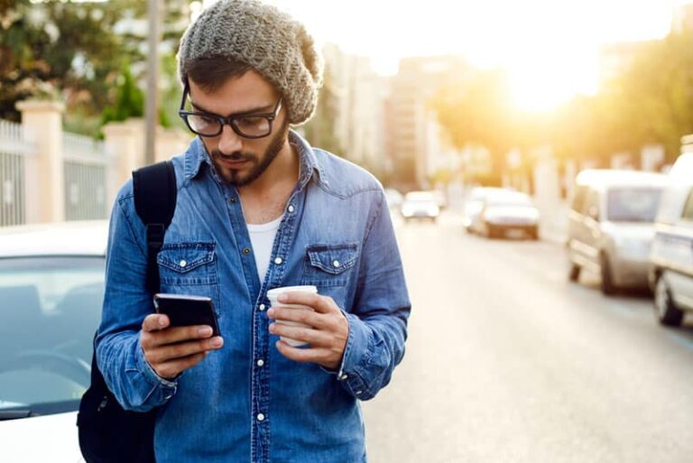 uomo con un caffè che cammina per strada