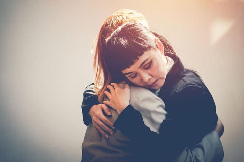 Two women hug to console
