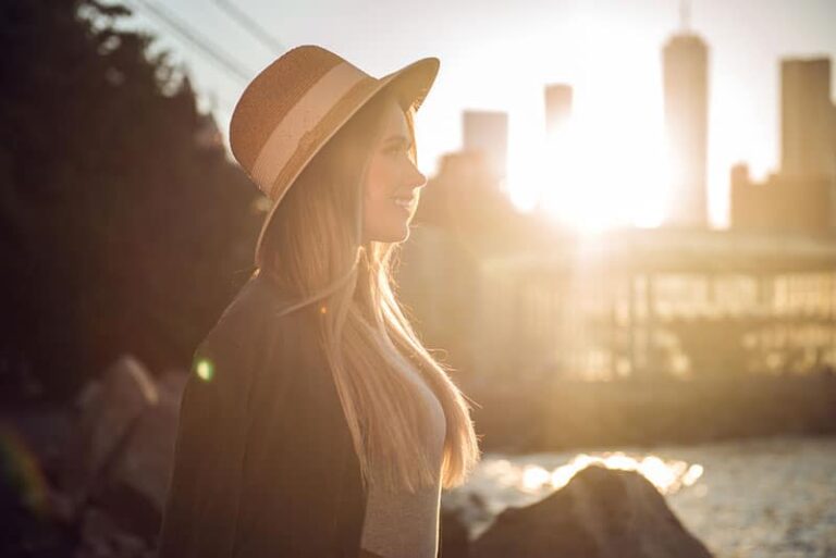 Beautiful woman in the city pier looking to the side smiling at sunset time