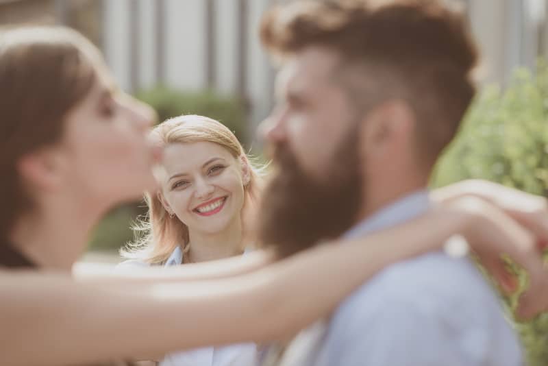 smiling woman looking at couple not jealous