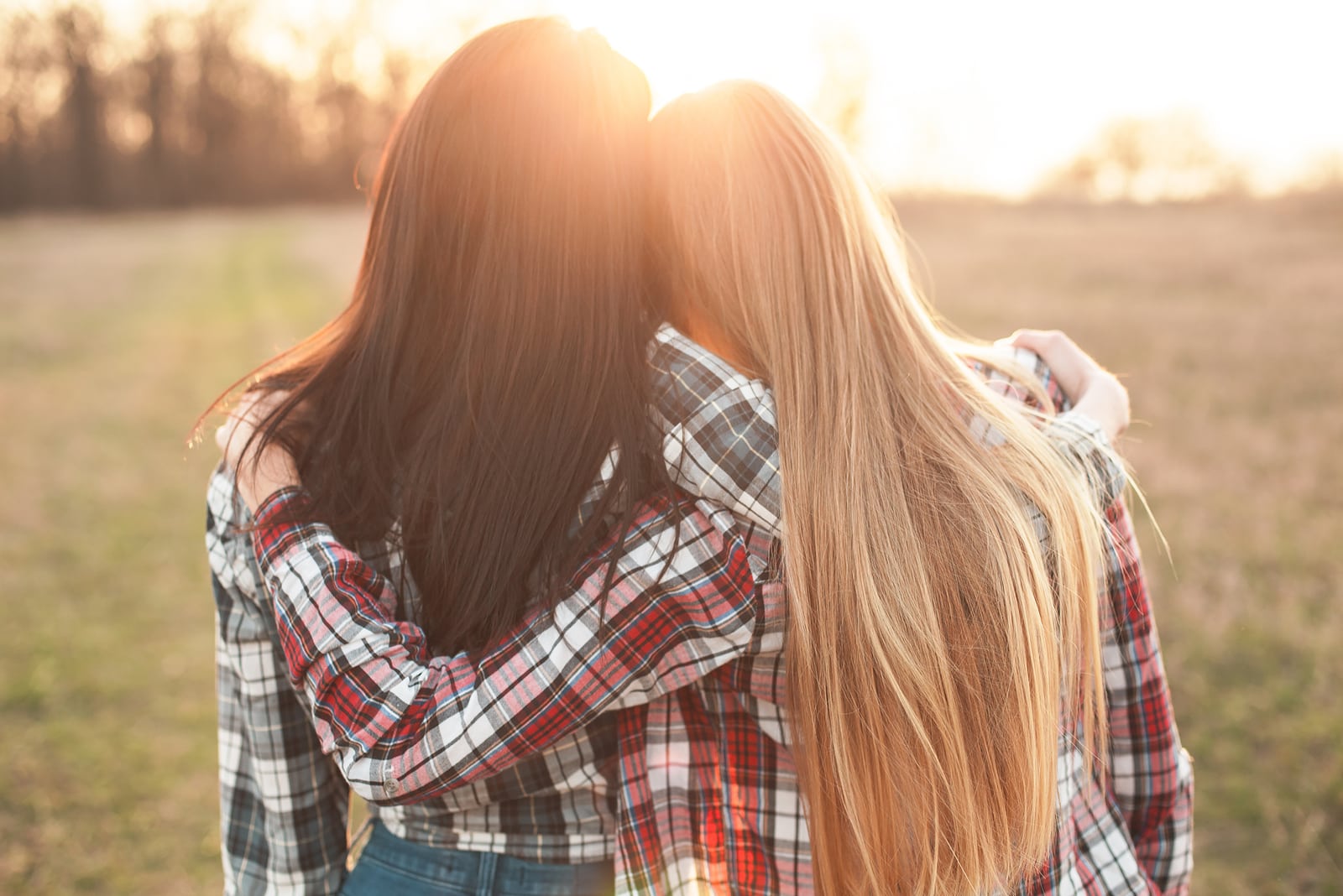 the blonde and brunette hug at sunset