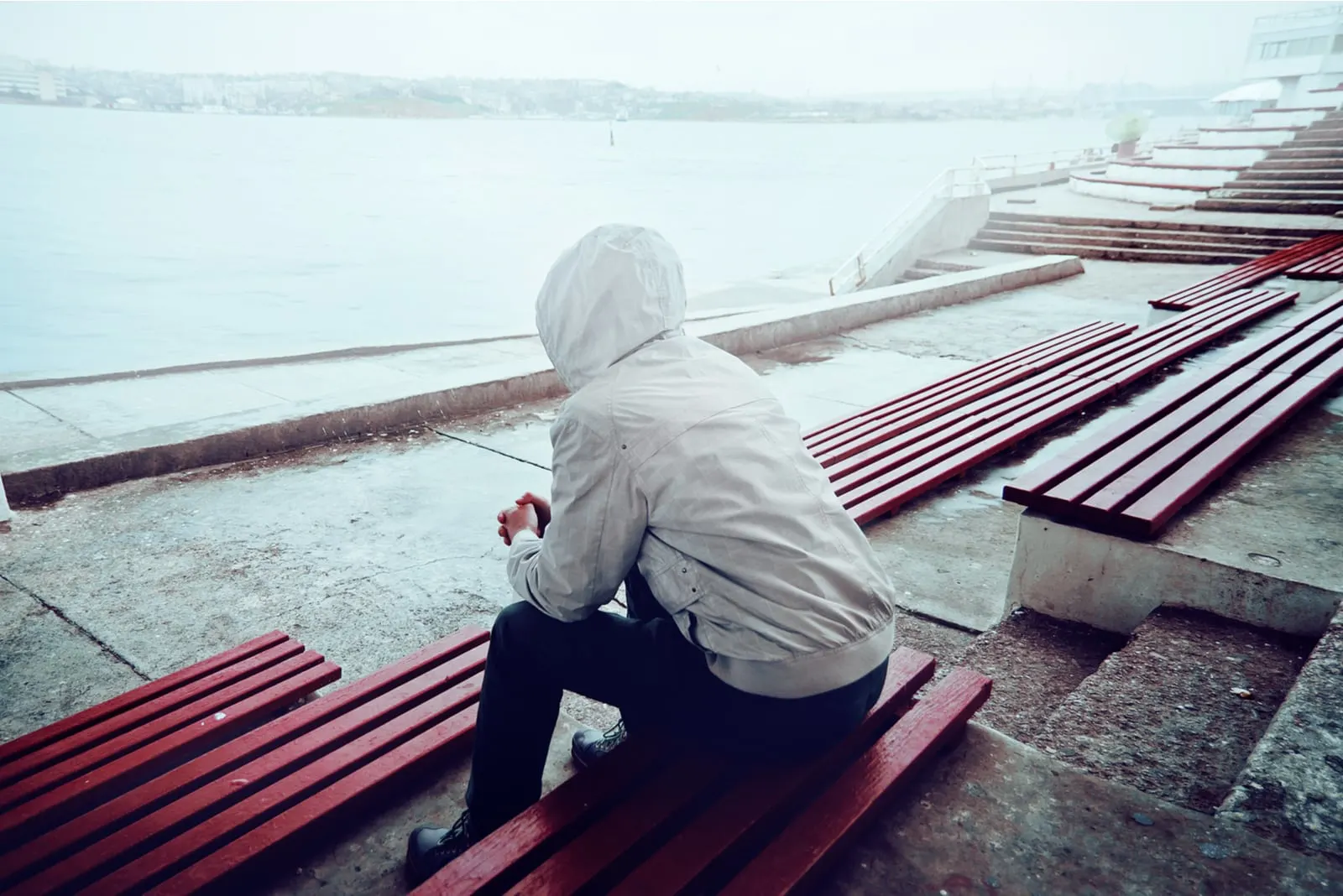 the man sits with his back turned