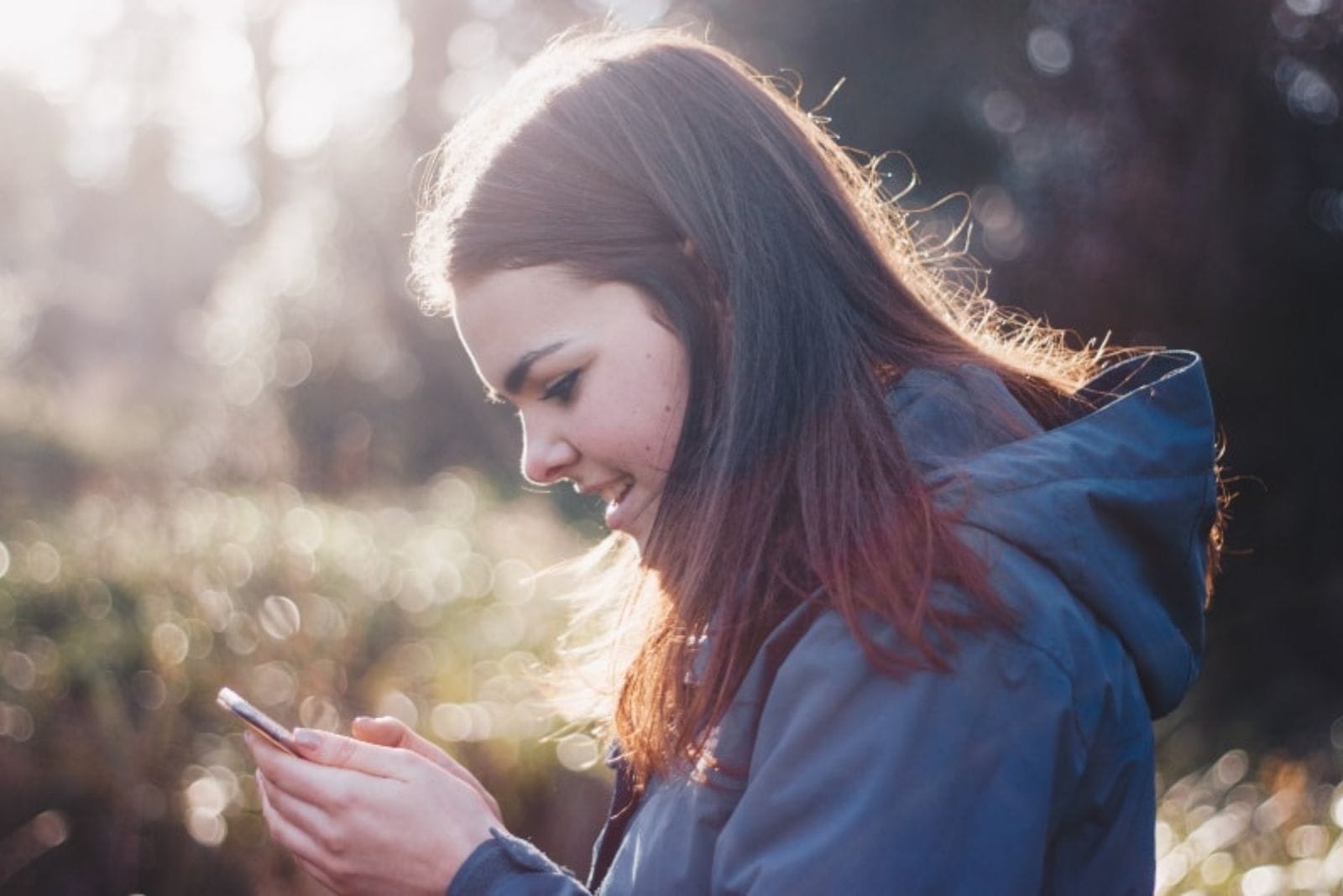 the woman smiles as she presses the phone