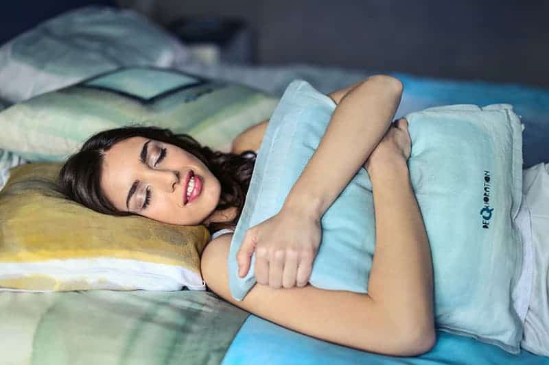 woman hugging a blue pillow