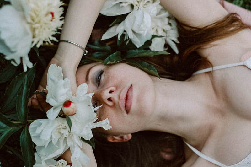 mulher deitada num campo com flores