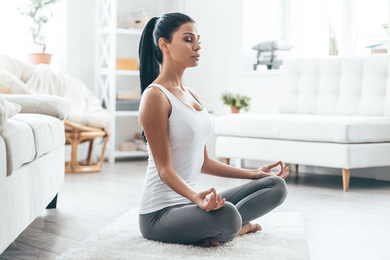 mulher a meditar em casa