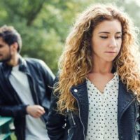 sad thoughtful woman standing in front of man