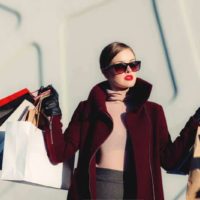 woman holding white black paper bags outside