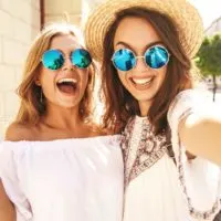 smiling two female with sunglasses taking selfie