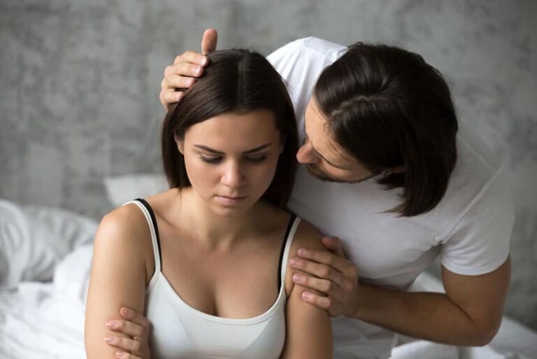 man apologizing to sad woman