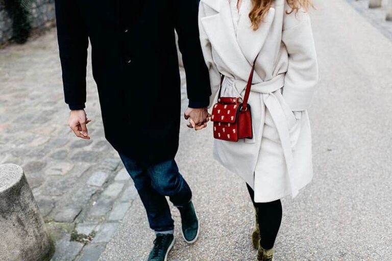couple holding hands and walking on street