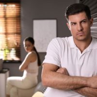 serious man sitting away from woman
