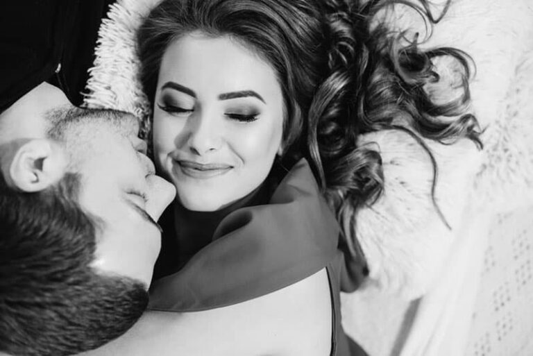 black and white photo of man kisses lovely woman on cheek