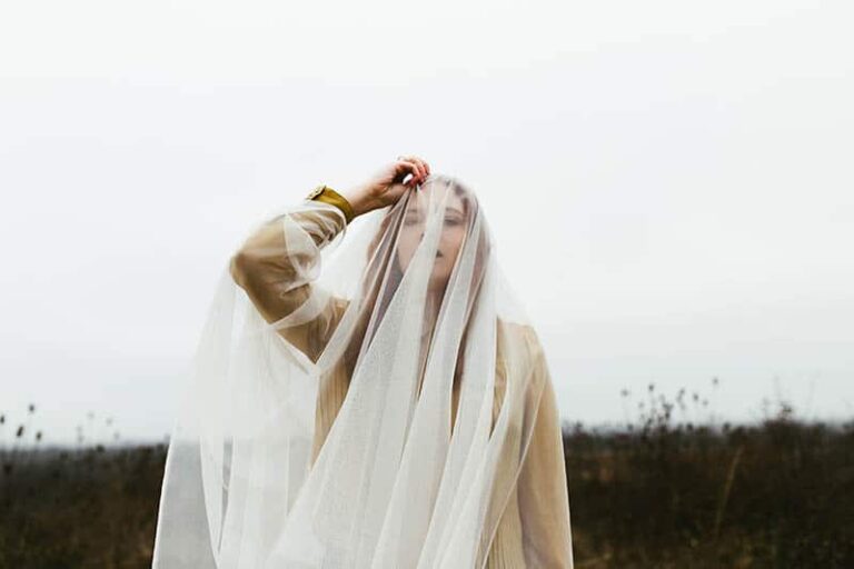 woman standing outside touching her hair