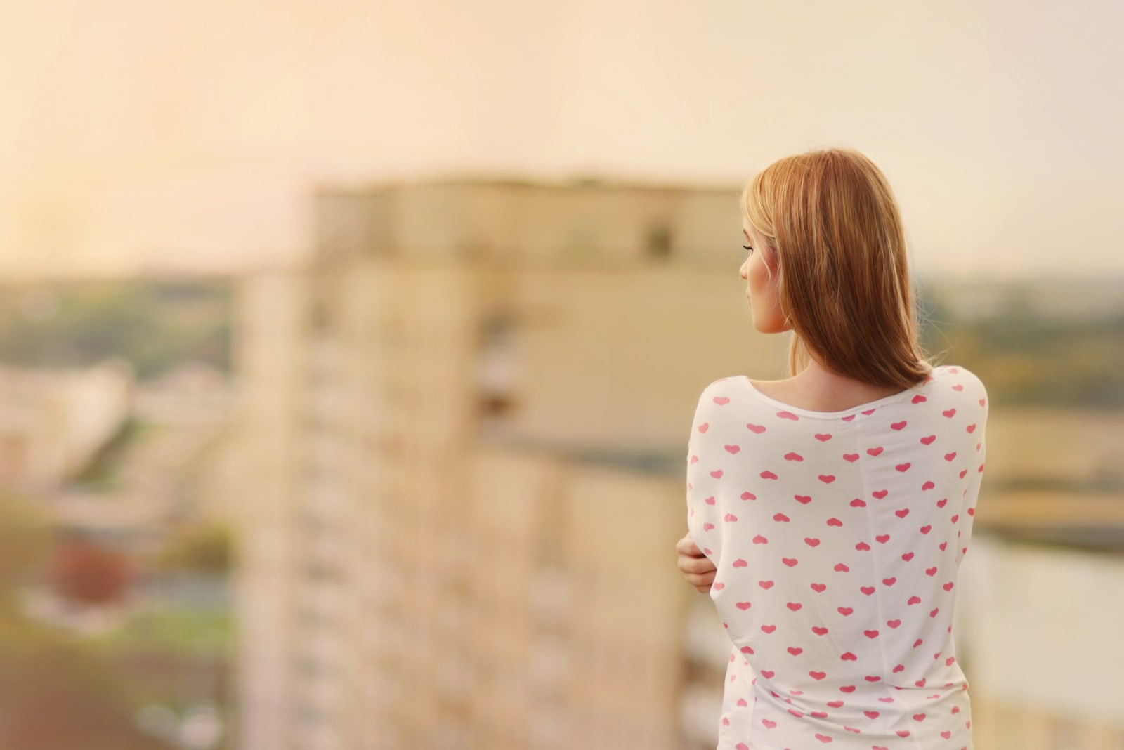 Beautiful blonde stands on the edge of the roof