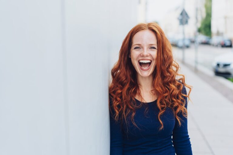 una donna con i capelli lunghi rossicci ride