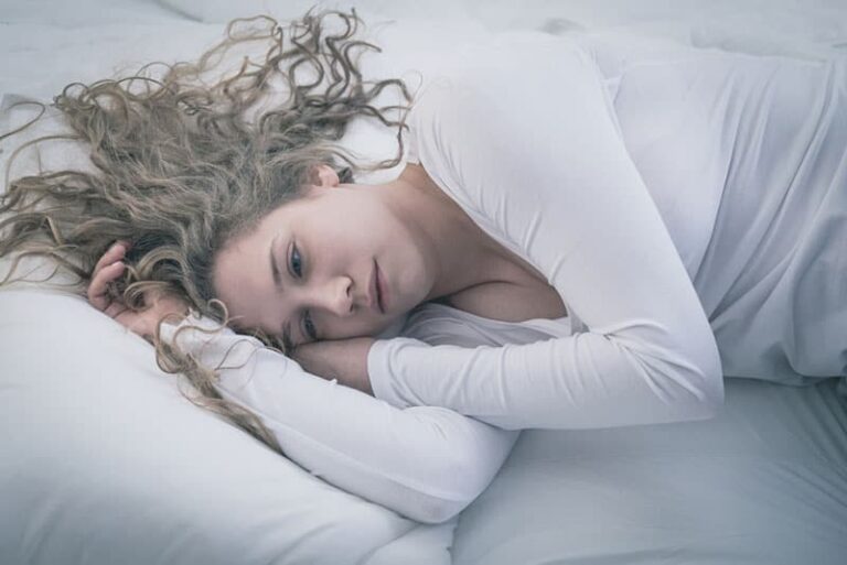 depressed woman lying in bed