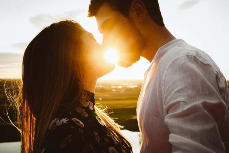 pareja besándose durante la puesta de sol