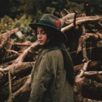 a woman with long black hair with a hat on her head