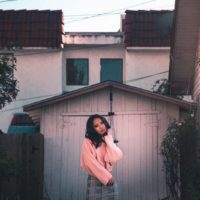 asian woman standing in front of wooden garage