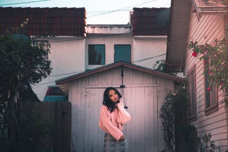 asian woman standing in front of wooden garage