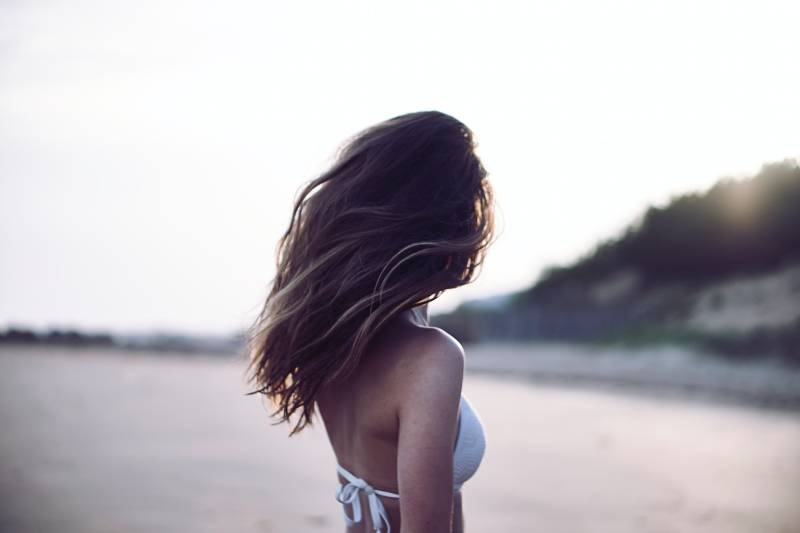 woman standing and wearing white bra