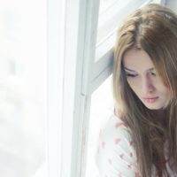 sad young woman sitting on the floor