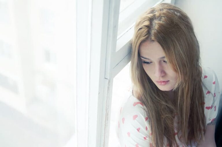 sad young woman sitting on the floor