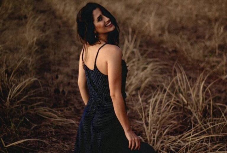 cheerful woman standing in brown field